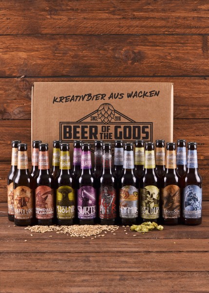 Das Göttergabe ProBIER-Paket Vol. 7 enthält 20 unterschiedliche Biersorten von Beer of the Gods. Die Flaschen sind vor einer stilvollen Box mit der Aufschrift 'Kreativbier aus Wacken' arrangiert. Perfekt für Bierliebhaber.